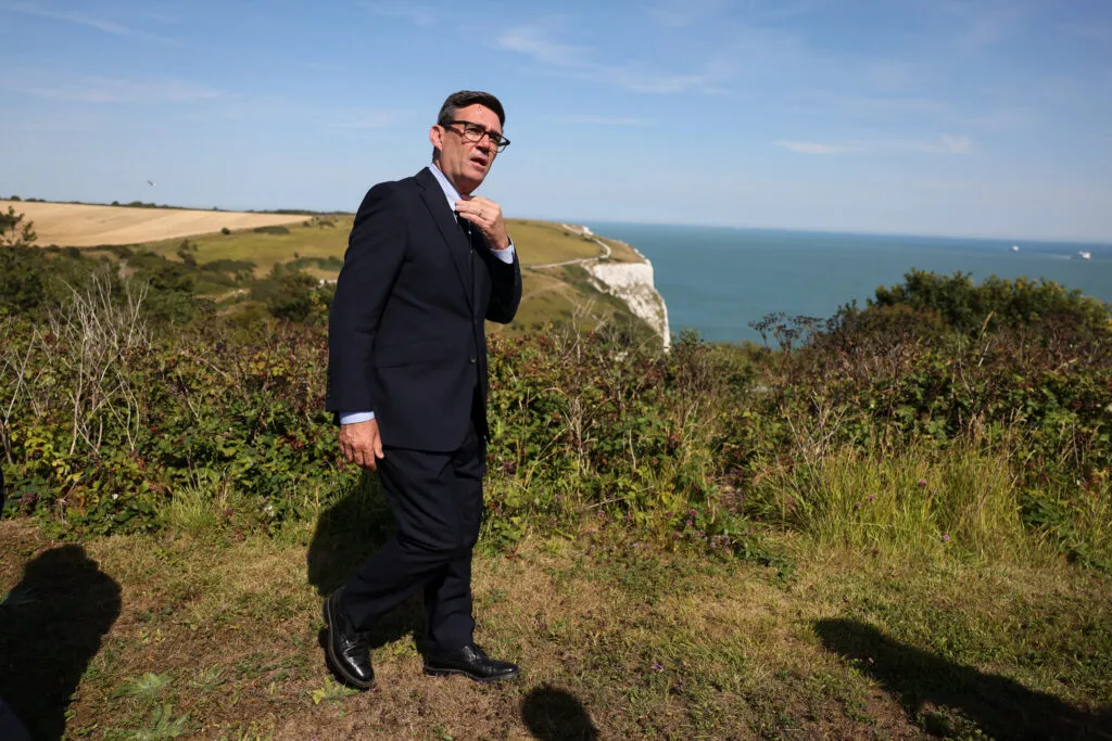 Andy Burnham marche près des falaises blanches de Douvres en Angleterre lors d’une visite au centre de coordination des secours maritimes le 2 août 2026. | Jack Taylor/ AFP via Getty Images